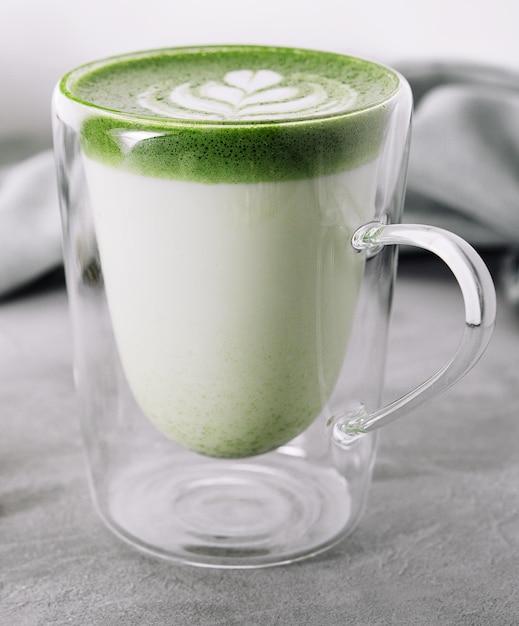 A freshly whisked matcha latte in a glass, creamy and green