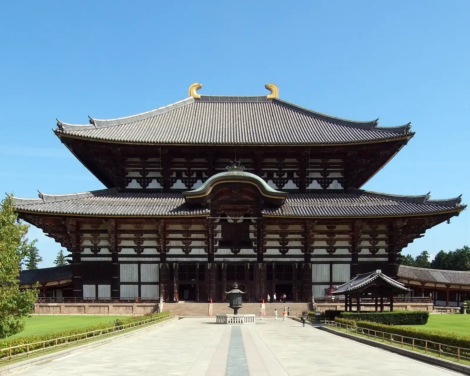 A sika deer bowing beside the Great Buddha Hall at Nara Park