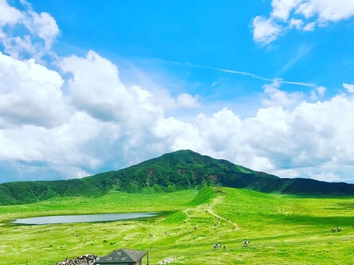 The grassy Kusasenri plain with its ponds and grazing horses, backed by Mount Aso